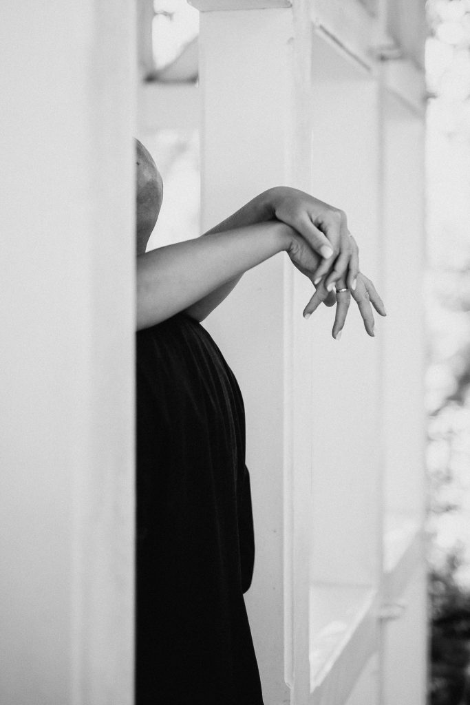 Hände einer Braut die ihren Mann umarmt während einer Hochzeitsreportage im Waldhotel Rheinbach.