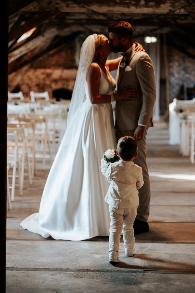 Brautpaar steht mit Ihrem Sohn in der Kornscheune in Köln Orr.