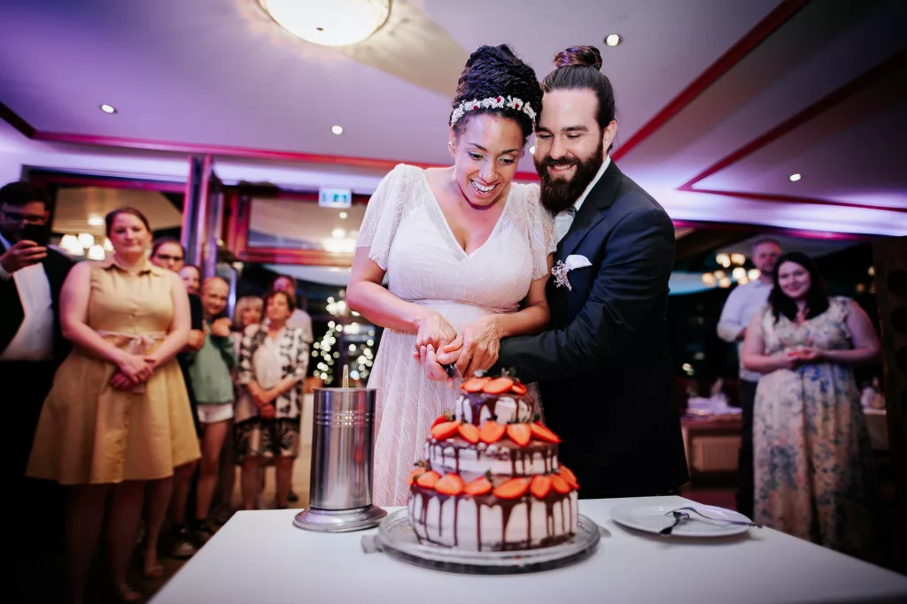Brautpaar beim Anschneiden der Hochzeitstorte im Waldcafé Bonn.,