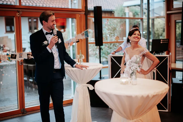 Brautpaar steht lachend nebeneinander.